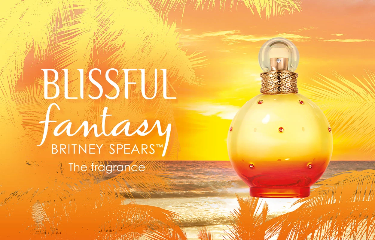 Britney Spearsin hajuvesipullo ”Blissful Fantasy”, taustalla rannan auringonlasku ja palmuja. Kuvassa on teksti ”Blissful fantasy Britney Spears™ The fragrance”. Pullo on keltainen ja oranssi, ja siinä on kultaisia ja punaisia yksityiskohtia.