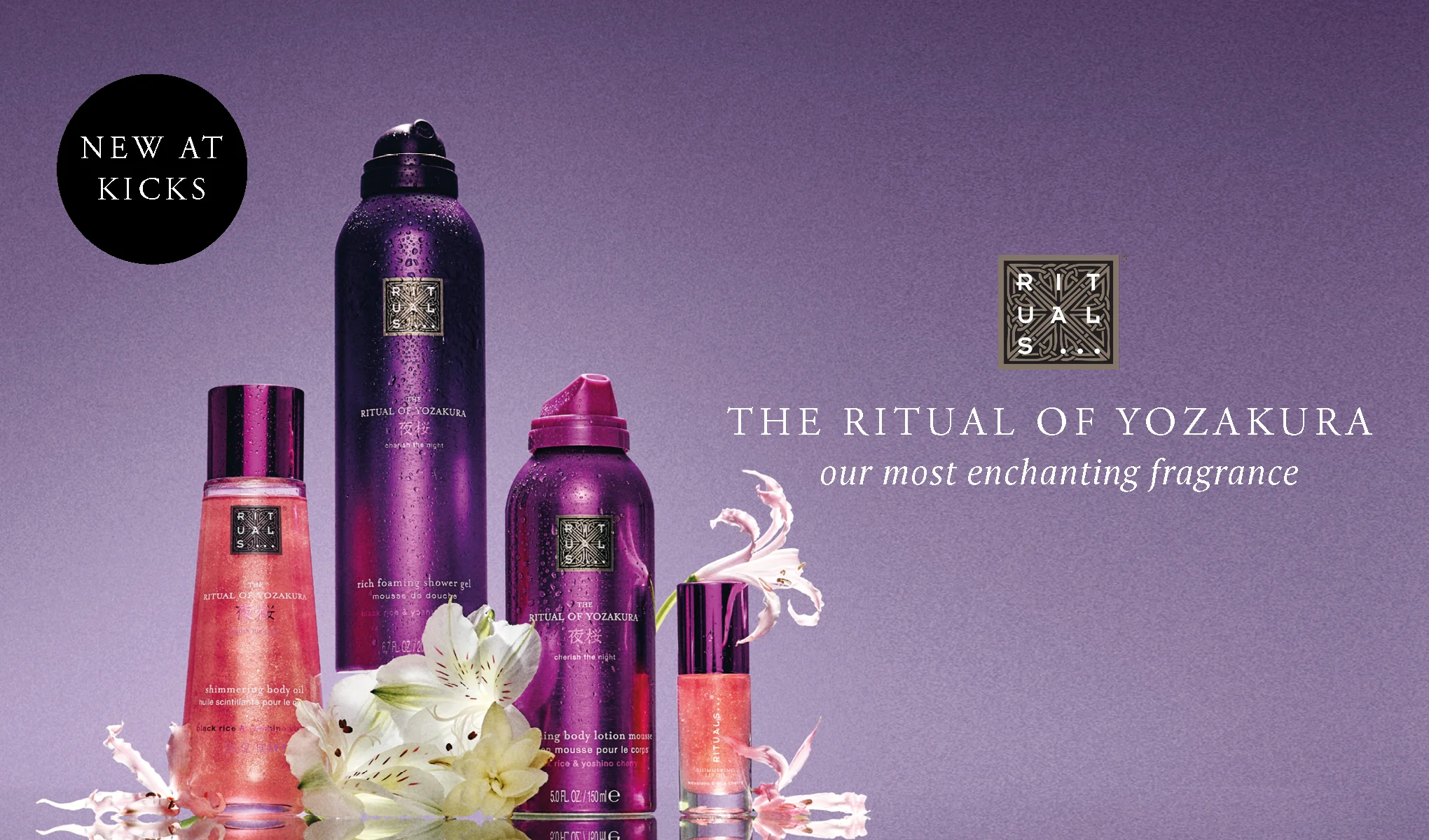 Rituals kroppsvårdsprodukter ur serien The Ritual of Yozakura visas mot en lila bakgrund: rich foaming shower gel, body lotion mousse, shimmering body oil och parfymolja med blommor framför. Texten “NEW AT KICKS”, Rituals-logotypen samt “THE RITUAL OF YOZAKURA – our most enchanting fragrance” syns i bilden.