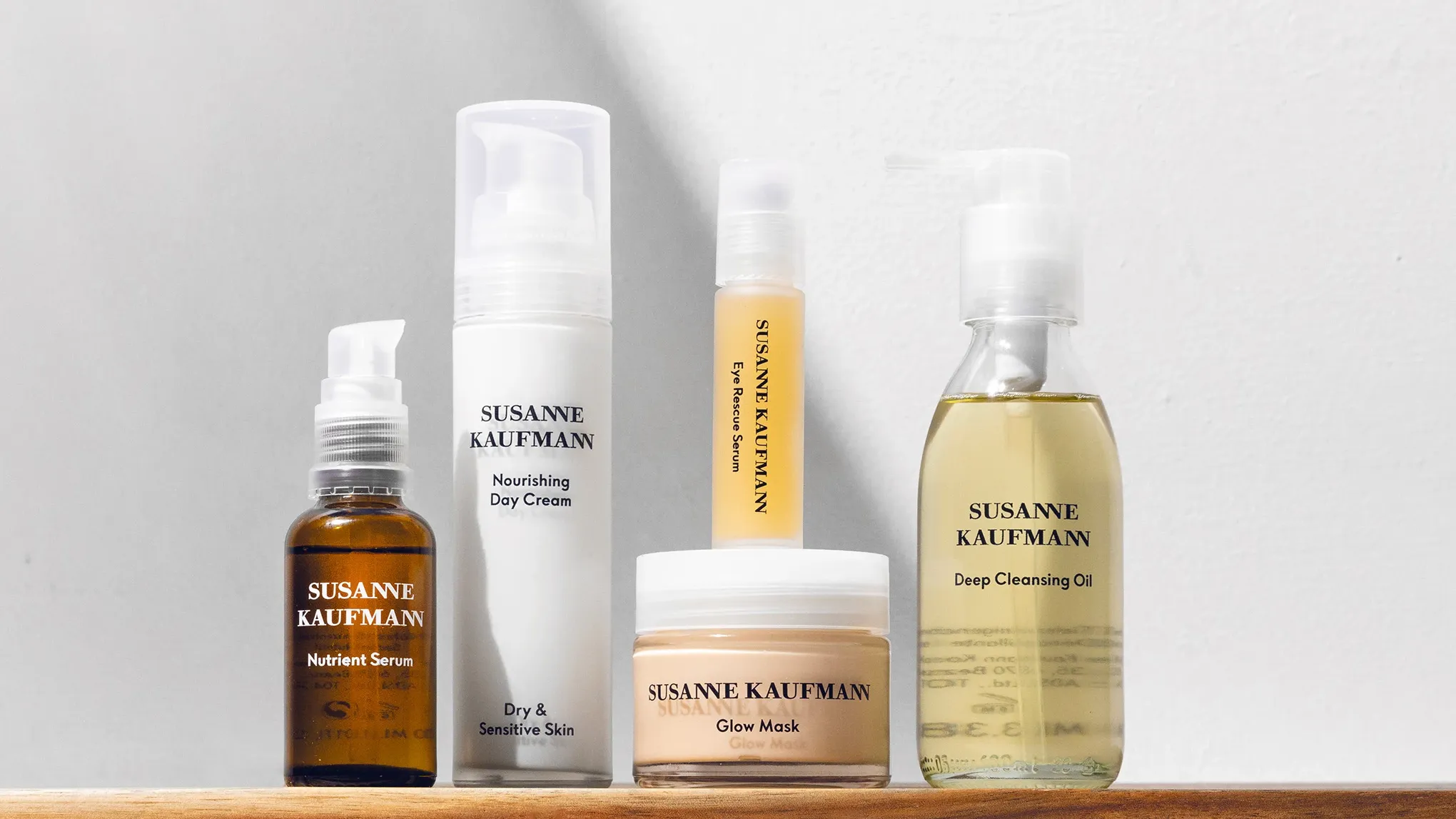 Fem produkter fra Susanne Kaufmann plassert på treverk mot en hvit bakgrunn.