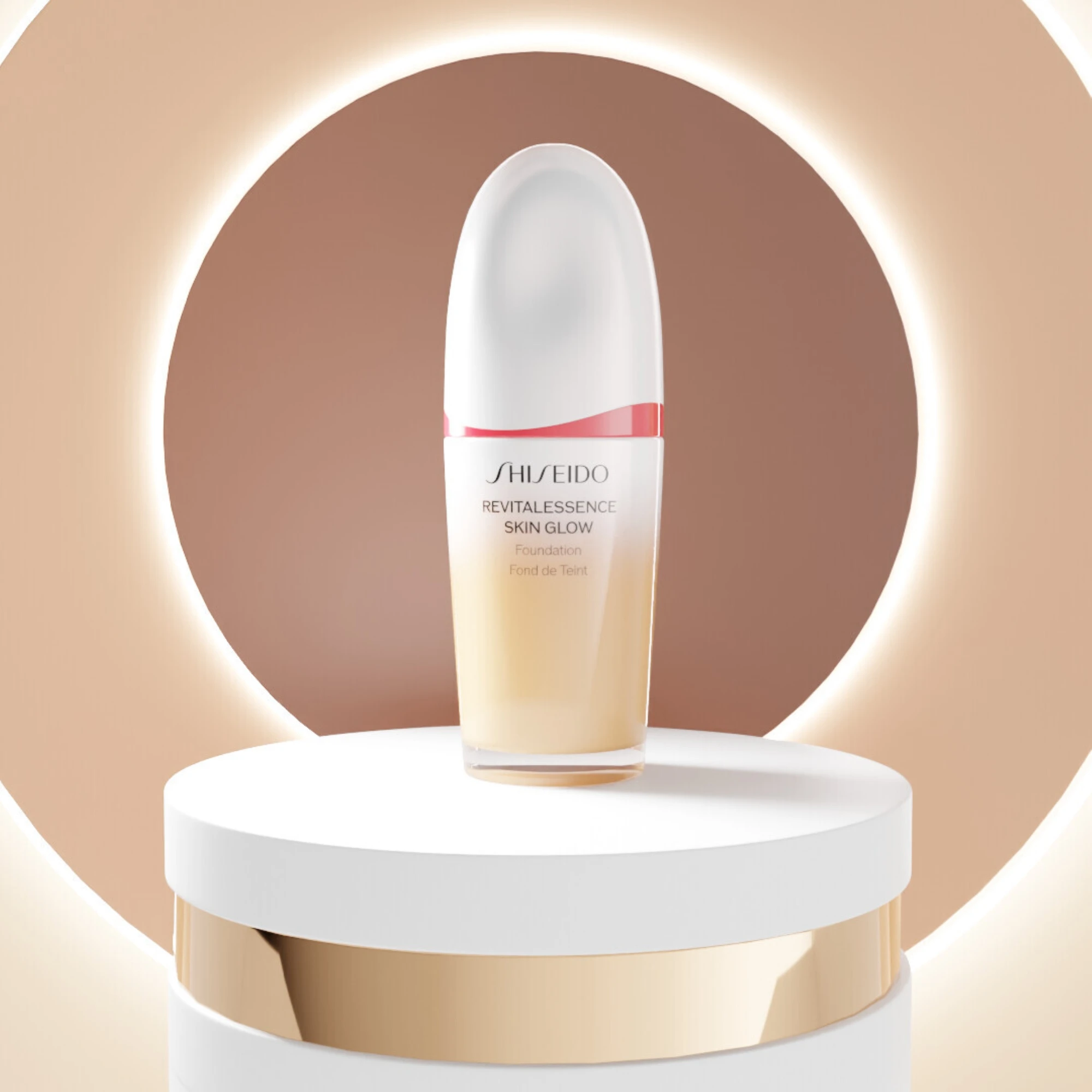 Shiseido Revitalessence Skin Glow -meikkivoide pullo esillä jalustalla pyöreän valokehän edessä.