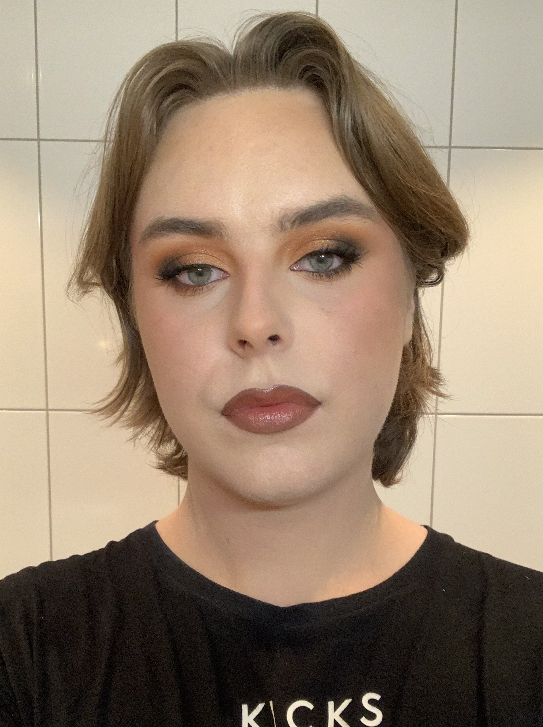 Person med makeup, som tittar in i kameran