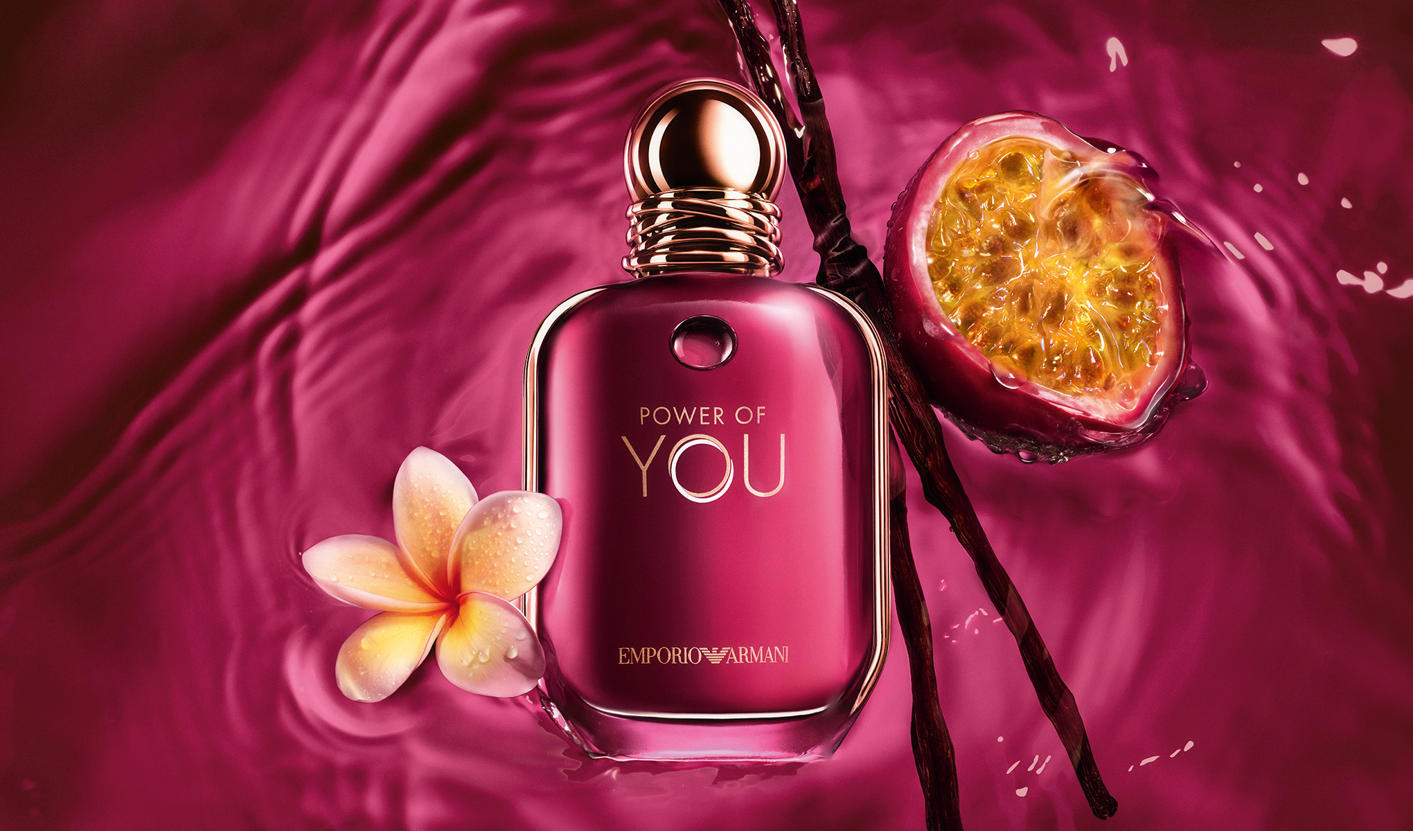 Emporio Armani Power of You -parfyymipullo vaaleanpunaisella taustalla, passionhedelmää, vaniljatankoja ja kukka.