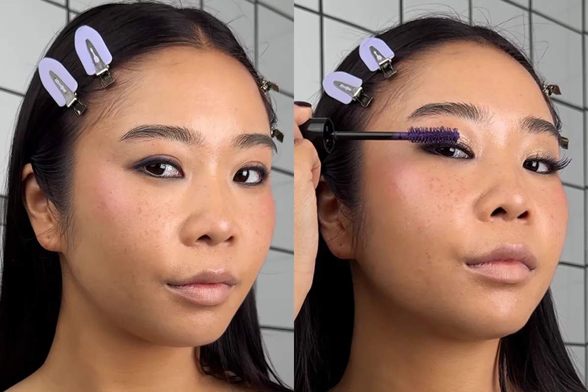 En stegvis tutorial som visar hur man sminkar sig till karaktären Rumi. Bilden visar en person med mörkt hår och lila hårklämmor, som applicerar mascara. Personen står mot en bakgrund med vita och svarta kakelplattor.