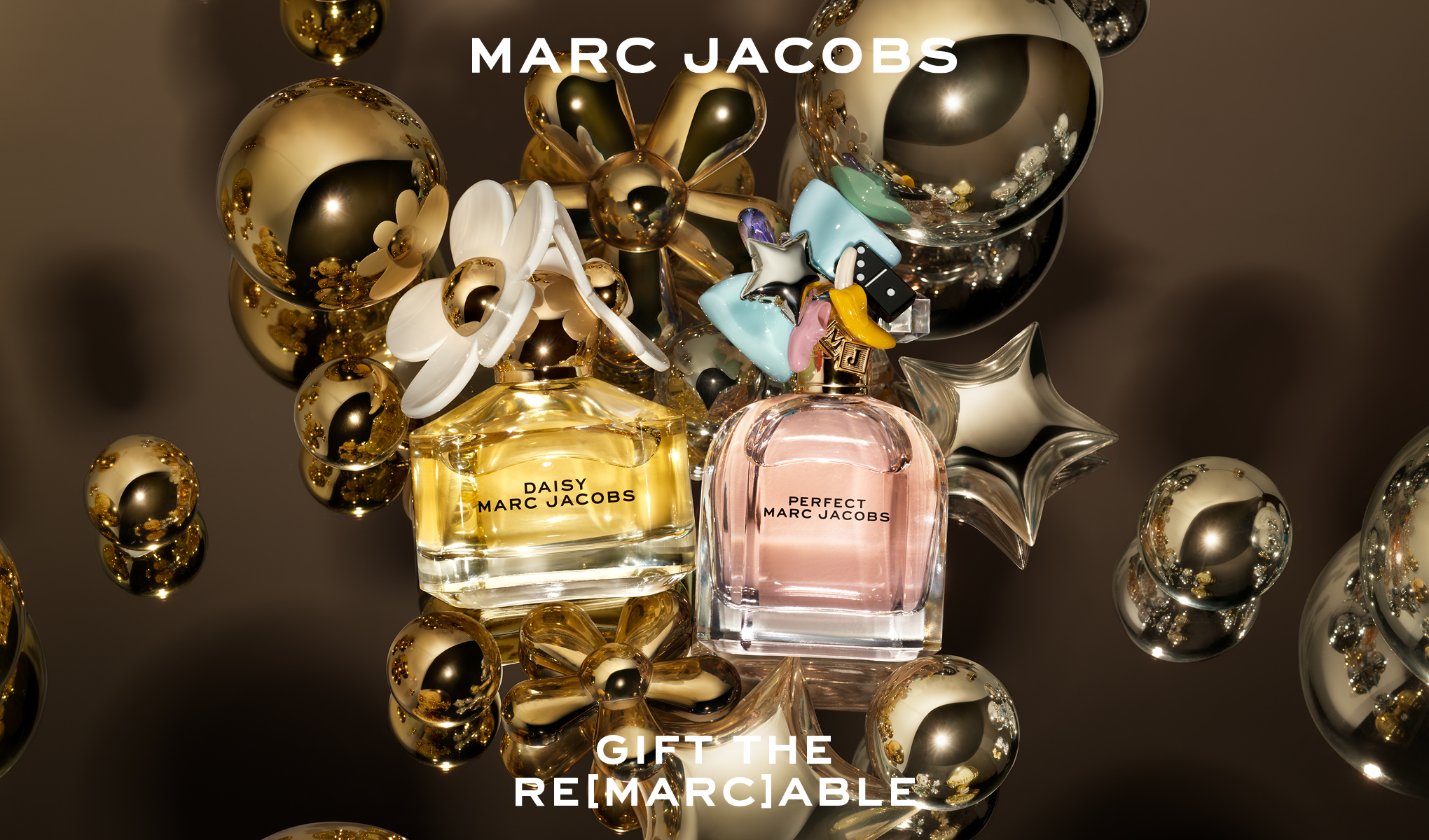 To Marc Jacobs-parfymeflasker, Daisy og Perfect, omgitt av gullfargede dekorasjonsballer og blomster. Teksten "MARC JACOBS" øverst og "GIFT THE RE[MARC]ABLE" nederst.