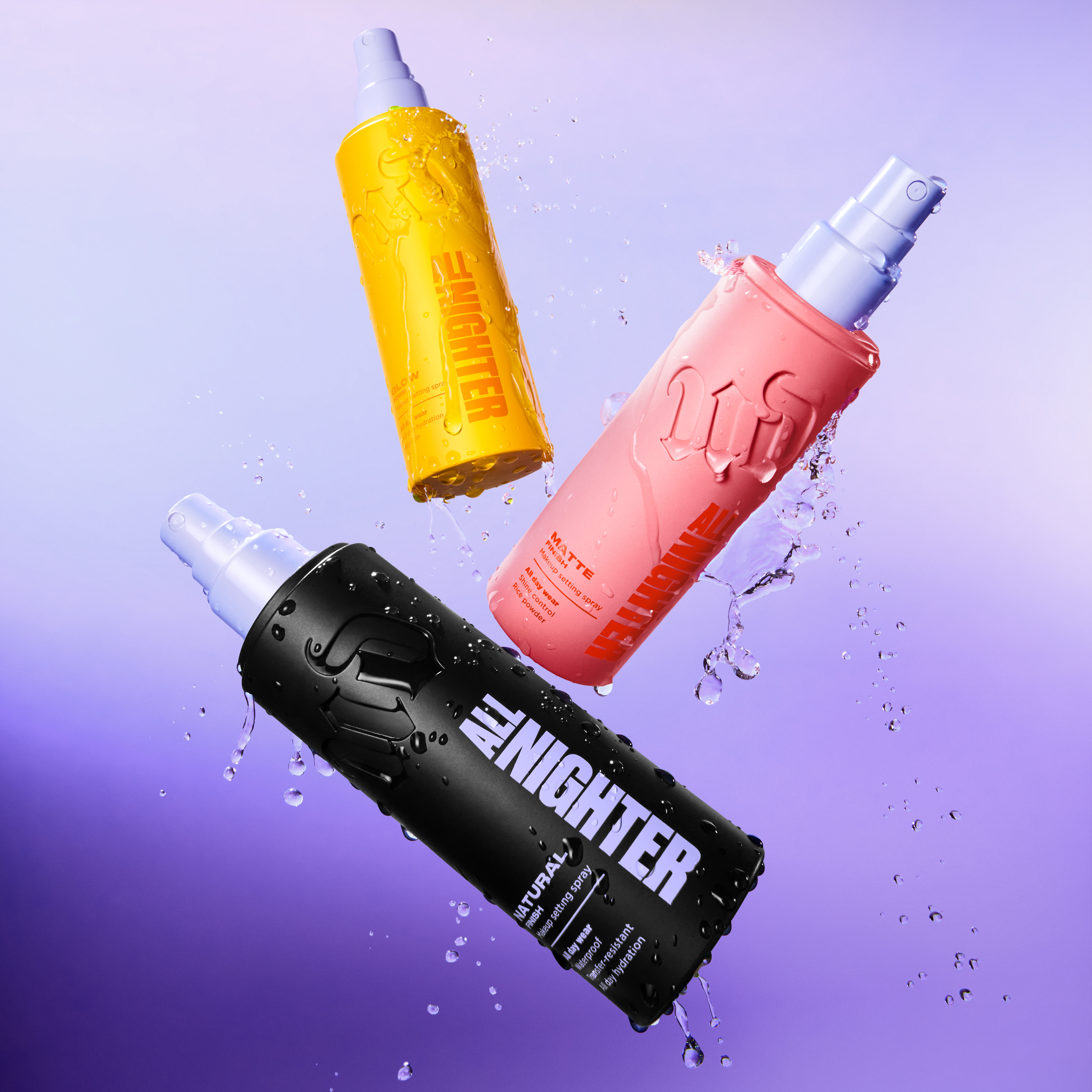 Tre Urban Decay All Nighter setting sprays i svart, rosa och gul flaska med spraypump mot lila bakgrund med vattendroppar. På flaskorna syns texterna “ALL NIGHTER”, “MATTE” och “GLOW”.
