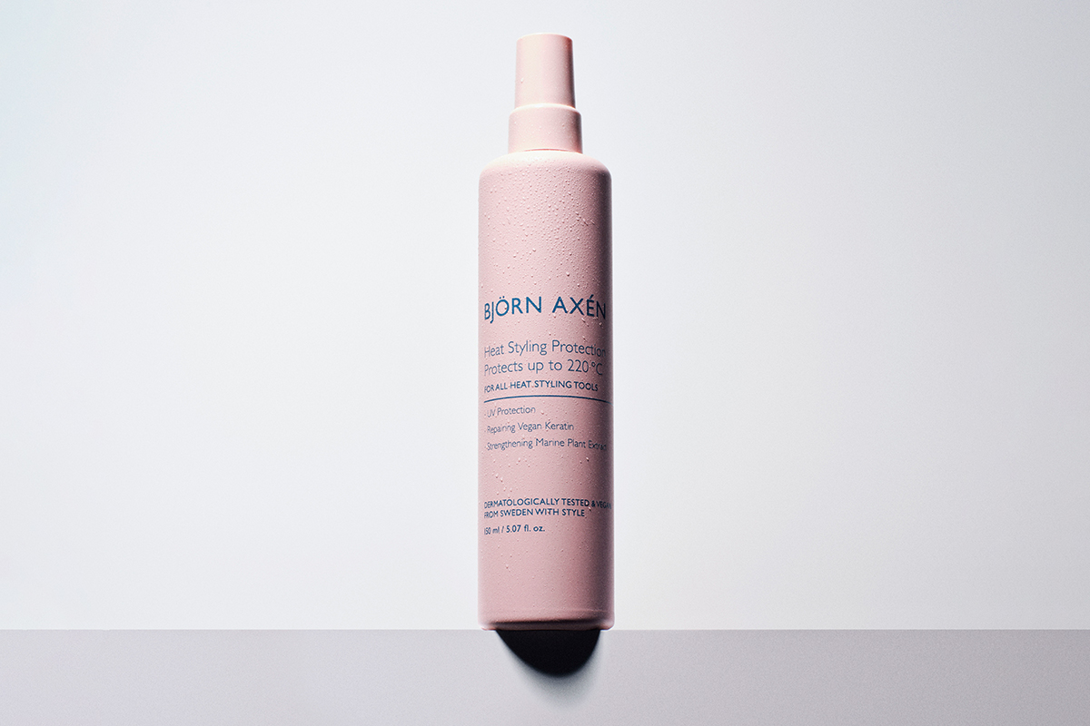 Björn Axén Heat Styling Protection. Produktet kommer i en rosa sprayflaske. Flasken står mot en hvit bakgrunn.