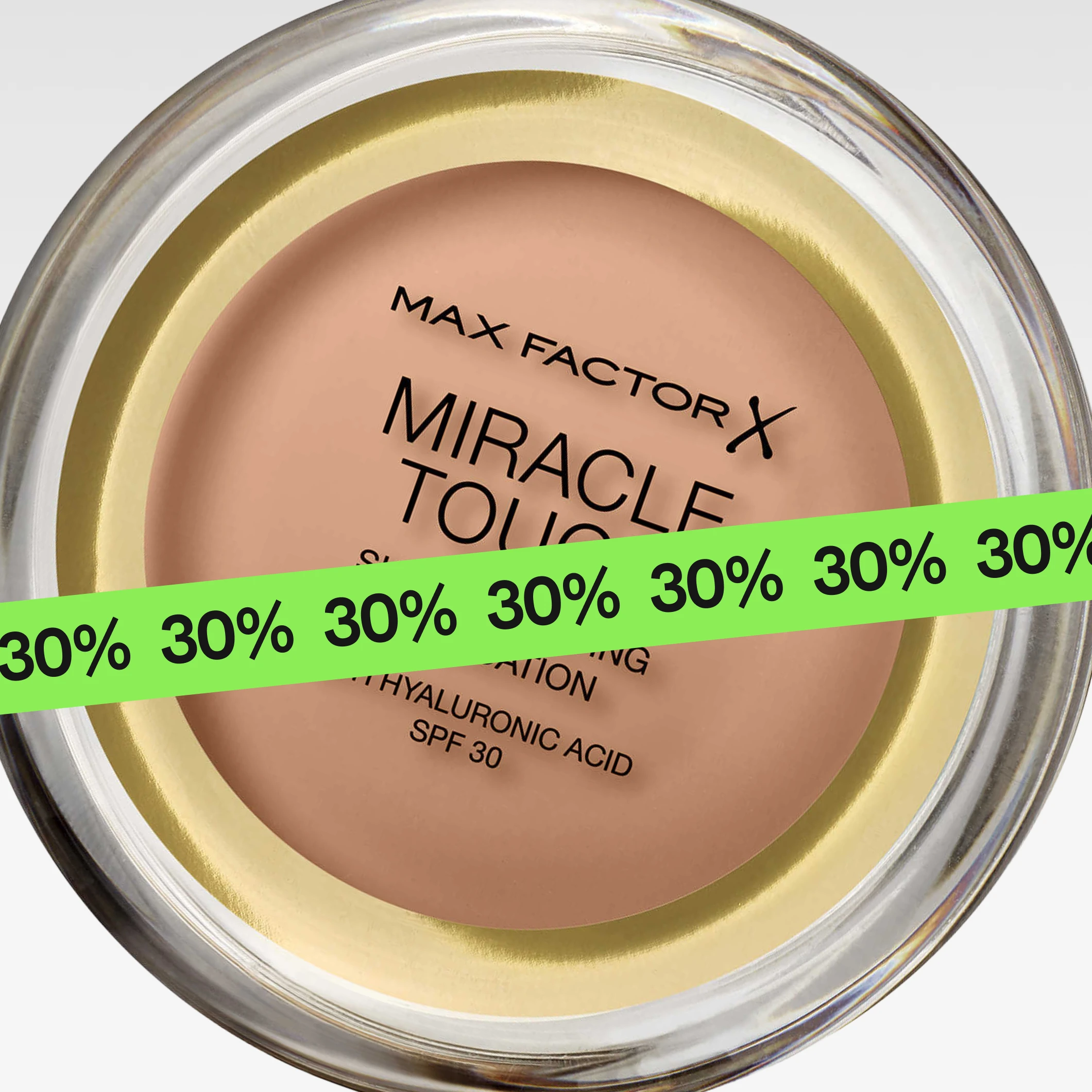 Närbild av “Max Factor Miracle Touch Skin Perfecting Foundation with Hyaluronic Acid SPF 30” i rund dosa, delvis täckt av en grön banderoll med upprepad “30%”.