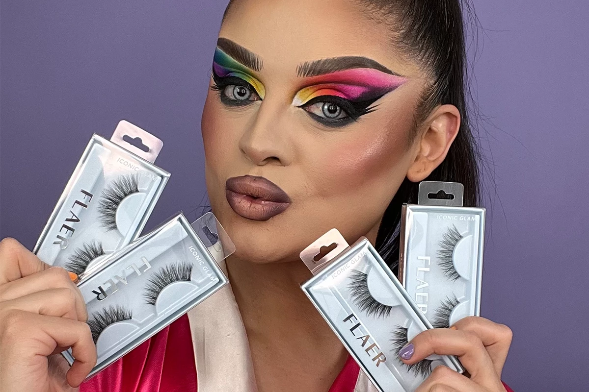 En person med suddat ansikte håller upp flera förpackningar med lösögonfransar mot en lila bakgrund.