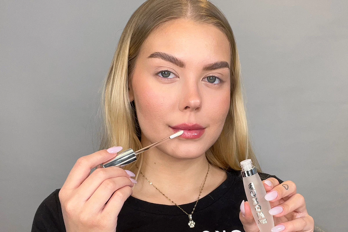 Kvinne som påfører lipgloss.