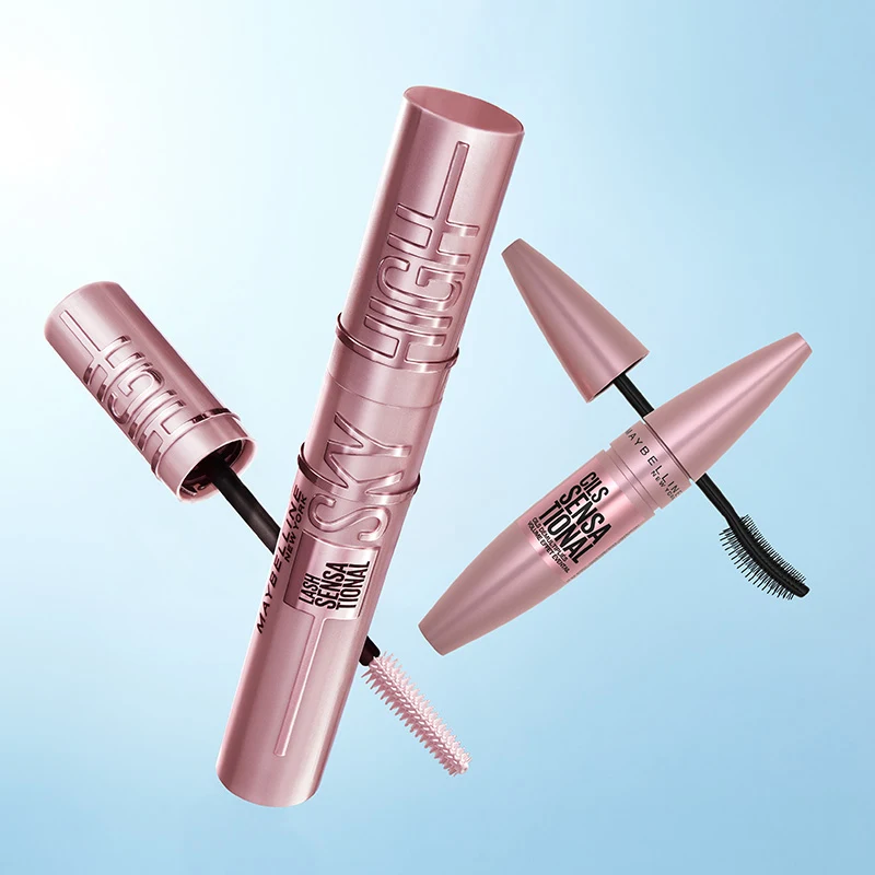 Maybelline mascara i rosa emballasje mot blå bakgrunn, med synlige børster.