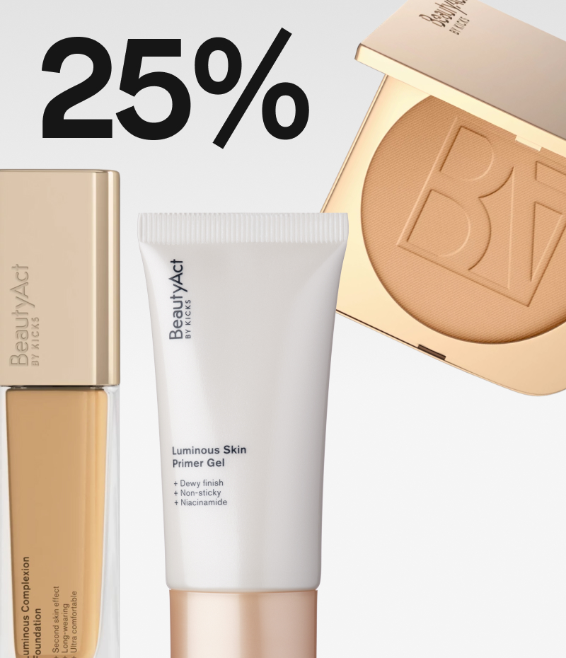 Foundation med gullkork, en tube med primer og et pudder  gulletui fra Beautyact mot en lys grå balgrunn