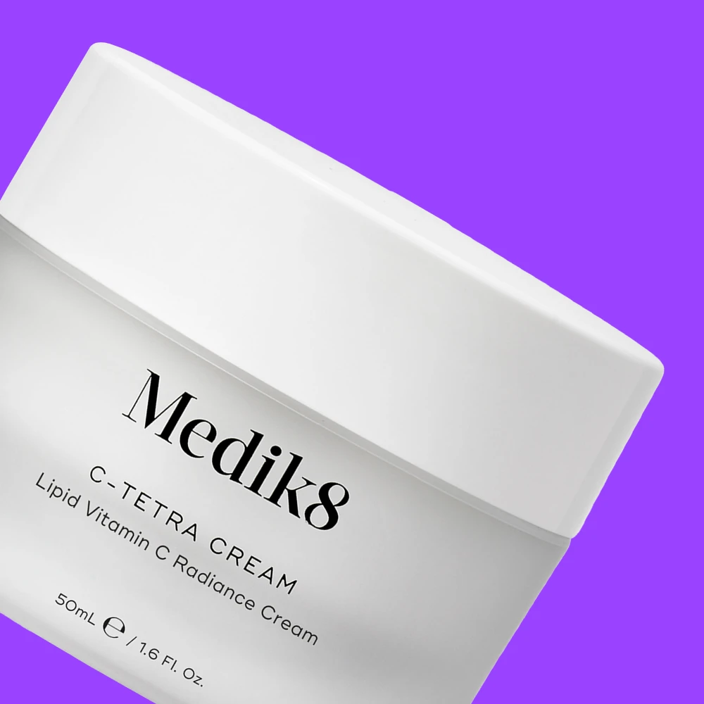 Medik8 C-Tetra Cream Lipid Vitamin C Radiance Cream valkoisessa purkissa violettia taustaa vasten.