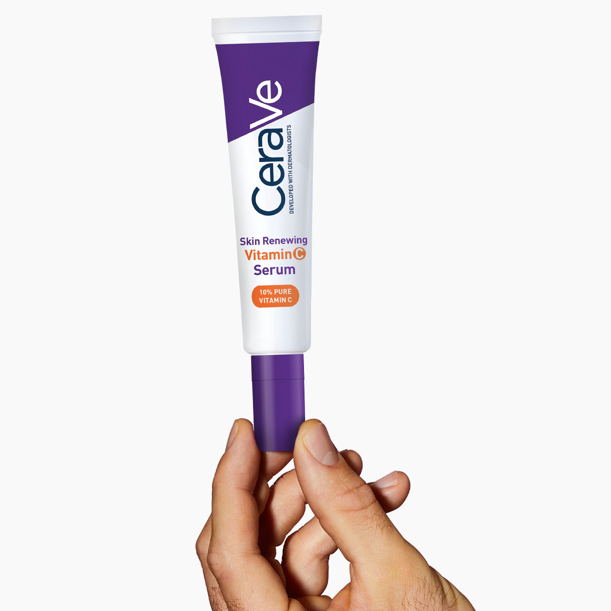 En hand håller CeraVe Skin Renewing Vitamin C Serum mot en vit bakgrund.