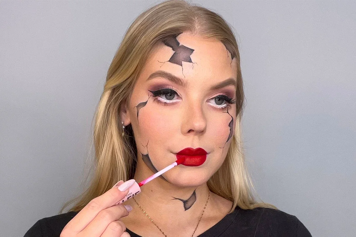 Den slutliga looken har en slående sprucken porslinsdocka med dramatisk ögonmakeup, djärva röda läppar och realistiska sprickor i ansiktet och på halsen.
