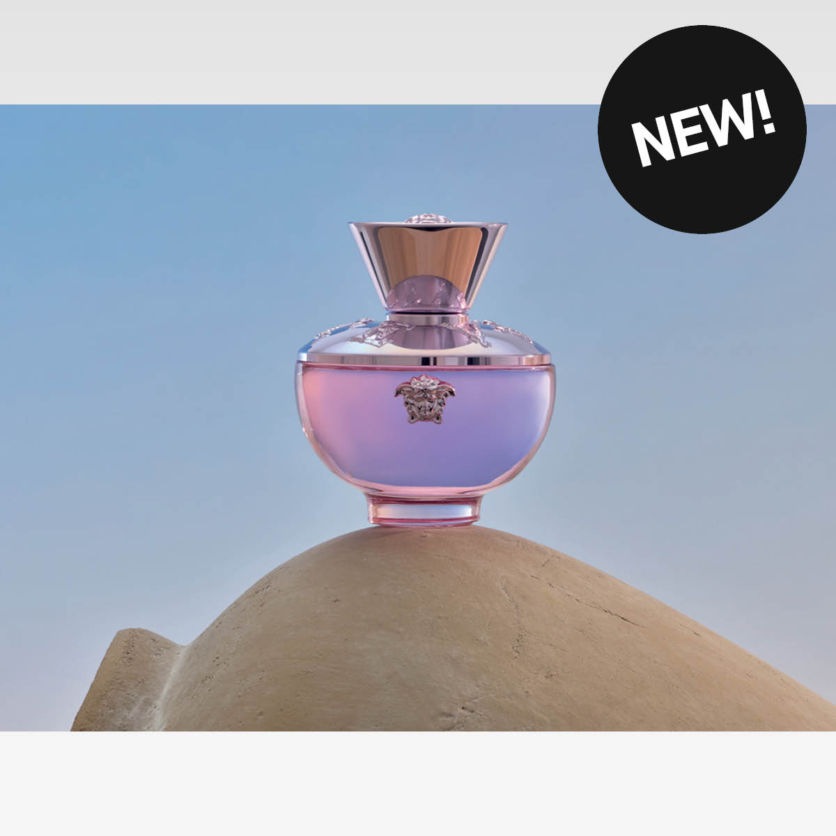 Rosa og lilla parfymeflaske, med teksten NEW!