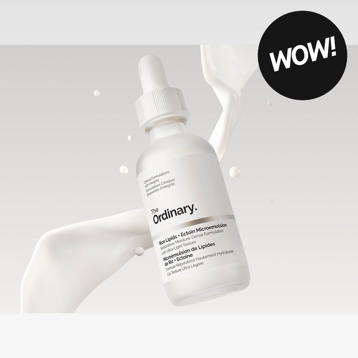 The Ordinary -seerumipullo vaalealla taustalla, ympärillä nestemäistä tekstuuria, teksti ”WOW!”.