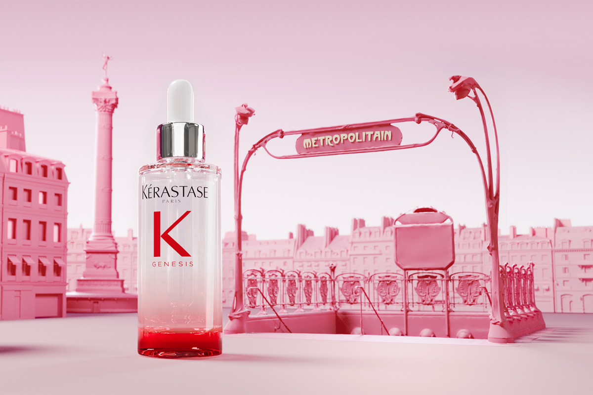 En flaska Kérastase Genesis serum placerad framför en stiliserad rosa bakgrund av Paris. Bakgrunden inkluderar en "Metropolitain" tunnelbaneskylt och byggnader, allt i rosa nyanser.