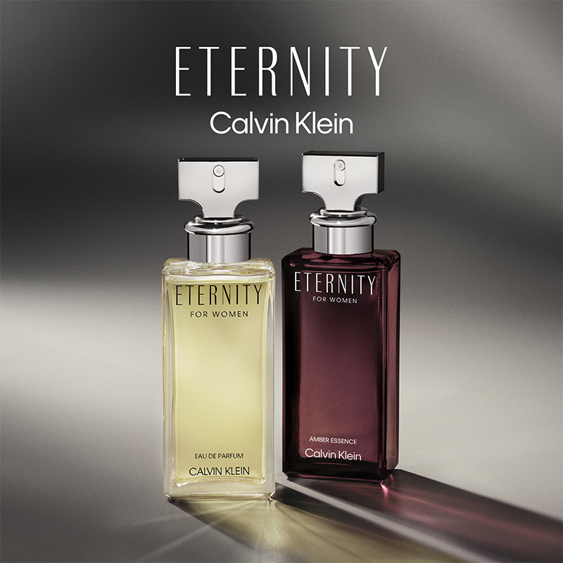 Två Calvin Klein-parfymflaskor märkta "Eternity for Women". Den vänstra flaskan är ljusgul och den högra är mörklila med texten "Amber Essence".