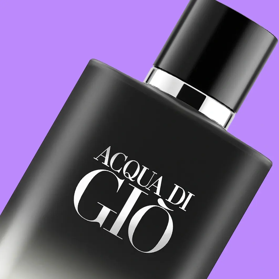 Närbild av Giorgio Armani Acqua di Giò-parfym i en matt svart flaska med silverfärgade detaljer och texten ”ACQUA DI GIÒ”, mot lila bakgrund.