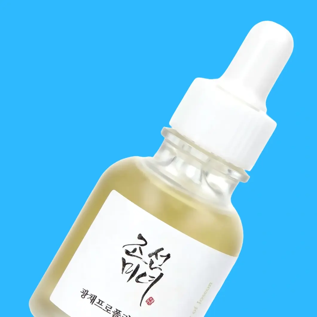 Beauty of Joseon Glow Pro serum i en lutande droppflaska med vit etikett mot en blå bakgrund.