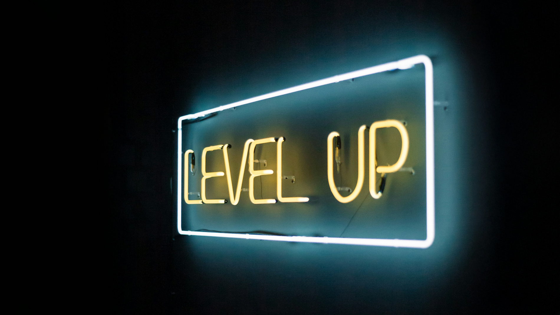 Neonskilt med teksten «LEVEL UP» i gult og med en blå ramme rundt