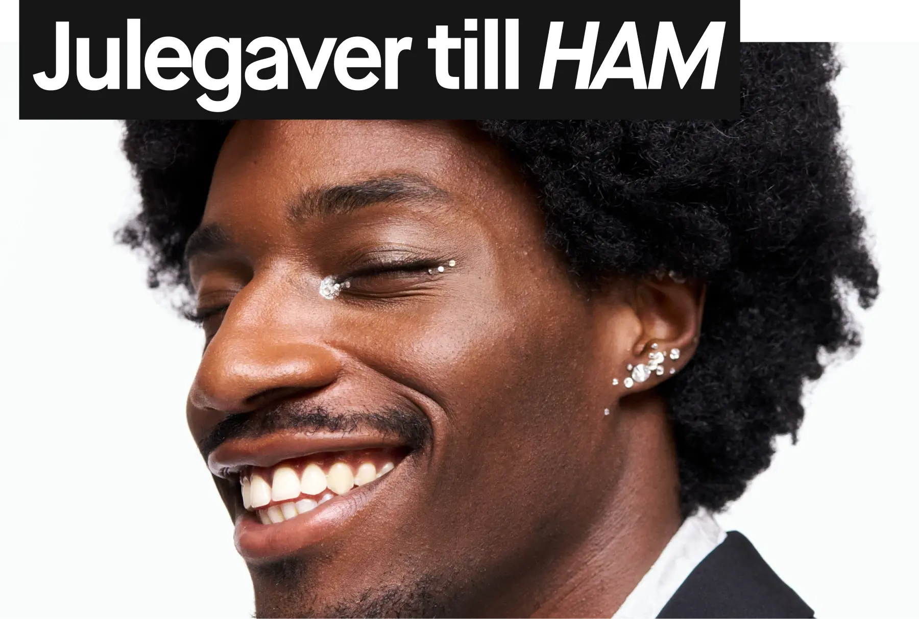 smilende mann i sort dress mot hvit bakgrunn