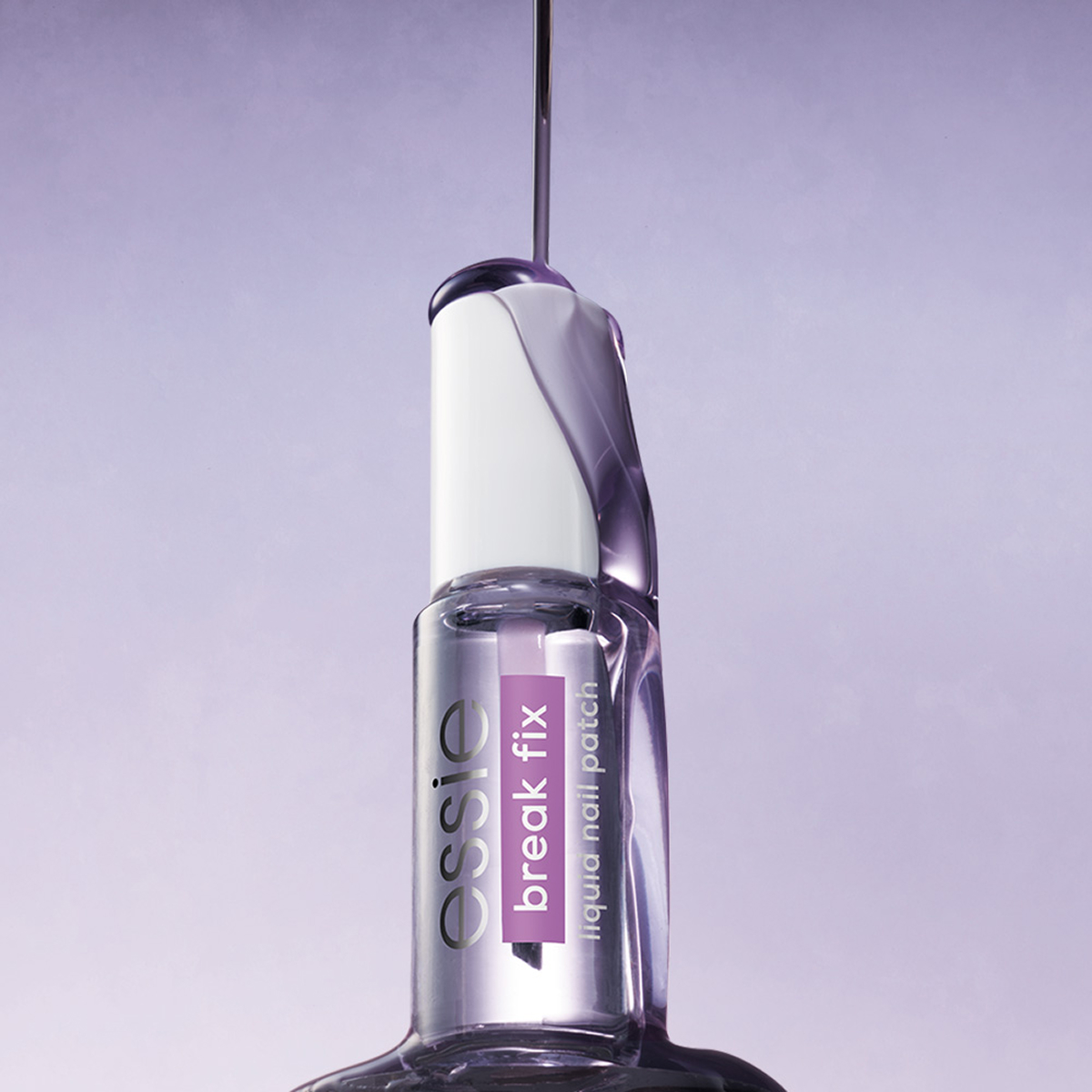 Essie Break Fix -kynnenkorjaustuote vaaleanlilaa taustaa vasten; violettia nestettä valuu pullon yli.