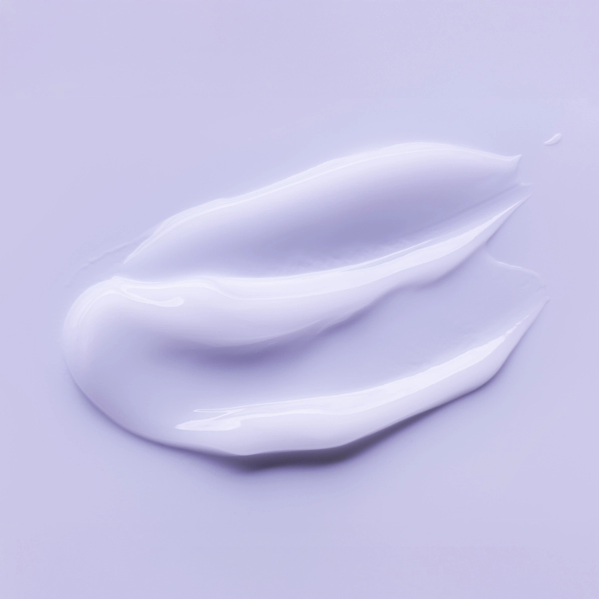 Ljuslila textur av skönhetsprodukt mot ljuslila bakgrund.