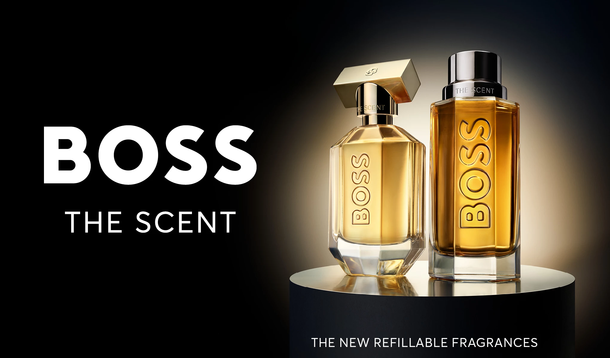 To parfymeflasker fra BOSS med teksten "Boss The Scent" og "The New Refillable Fragrances". Flaskene står på en rund sokkel mot en mørk bakgrunn med en lys gradient.