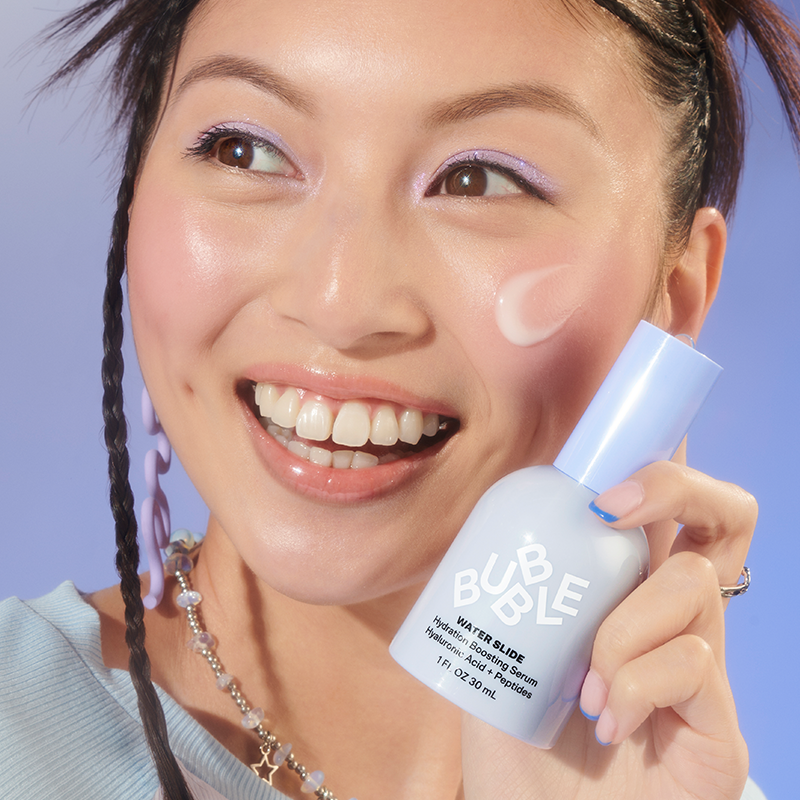 Bubble Water Slide fuktighetsgivande serum i en ljusblå flaska. Bakgrunden är blå.