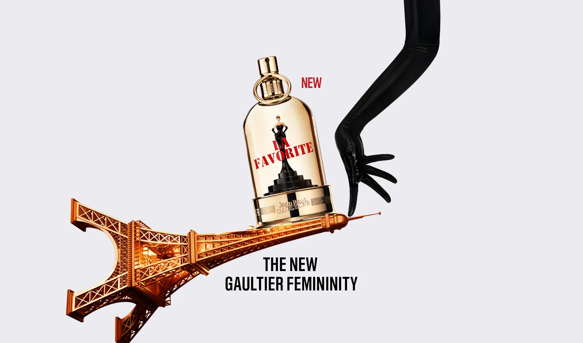 Jean Paul Gaultier La Favorite Eau de Parfum vises på en skråstilt Eiffeltårn-silhuett mens en hånd i en lang svart hanske holder parfymeflasken. Synlig tekst: "NEW", "LA FAVORITE", "Jean Paul Gaultier" og "THE NEW GAULTIER FEMININITY".