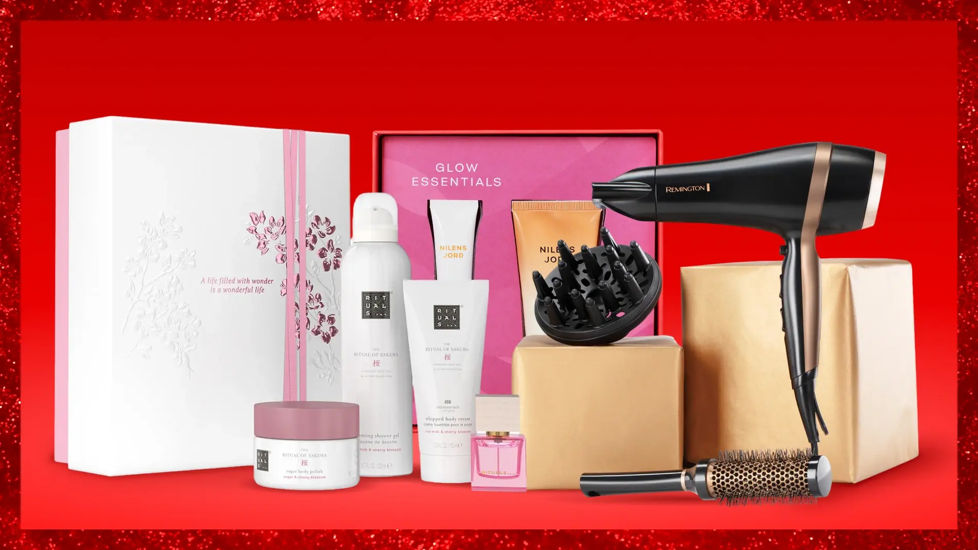Skönhets- och hårprodukter på röd bakgrund: Rituals presentkit med 'A life filled with wonder is a wonderful life', 'Glow Essentials' box, Rituals of Sakura- och Nilens Jord-produkter, Remington hårfön och borste.
