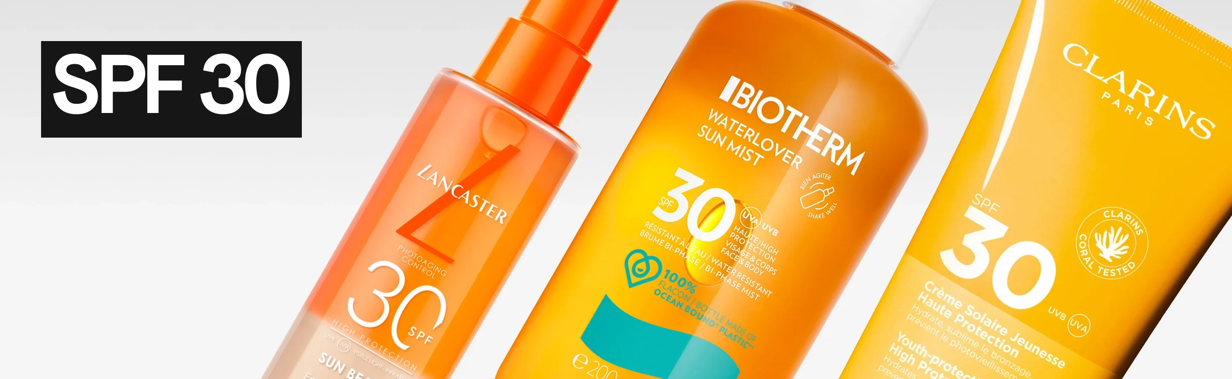 Flere solbeskyttelsesprodukter mot lys bakgrunn med teksten “SPF 30” i hvit tekst på svart bakgrunn til venstre. Synlige produkter er Lancaster Sun Beauty SPF 30 spray, Caudalie Vinosun Protect SPF 30 tube og Biotherm Waterlover Sun Mist SPF 30 spray.