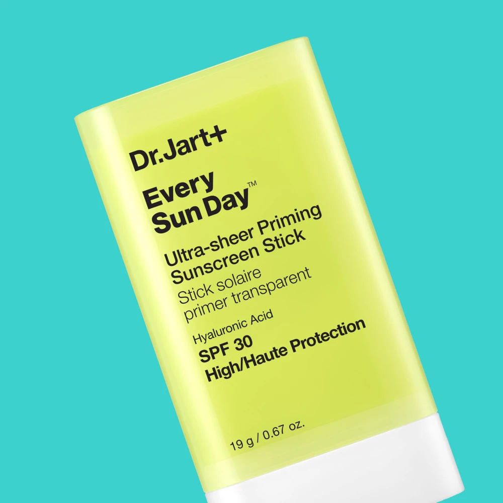 Dr. Jart+ Every Sun Day Ultra-sheer Priming Sunscreen Stick SPF 30. Keltainen aurinkosuojapuikko turkoosilla taustalla.