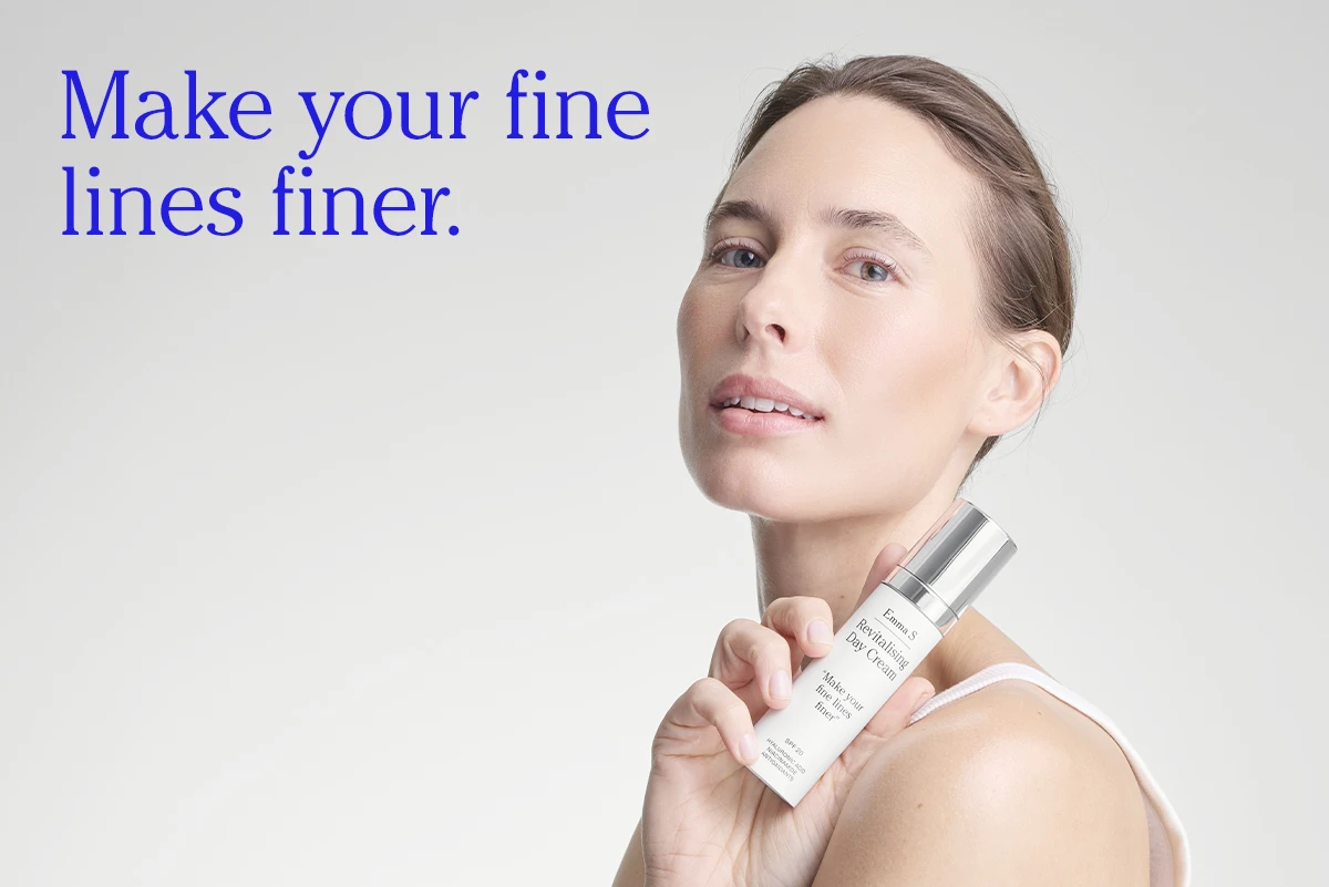Person håller en flaska ansiktskräm från Emma S med texten “Revitalising Day Cream” och “Make your fine lines finer”, bredvid texten “Make your fine lines finer.” på en ljus bakgrund.