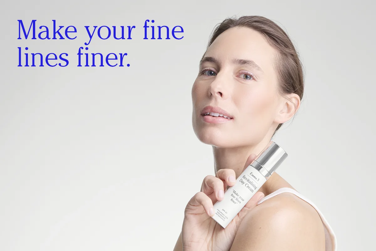 Person håller en flaska ansiktskräm från Emma S med texten “Revitalising Day Cream” och “Make your fine lines finer”, bredvid texten “Make your fine lines finer.” på en ljus bakgrund.