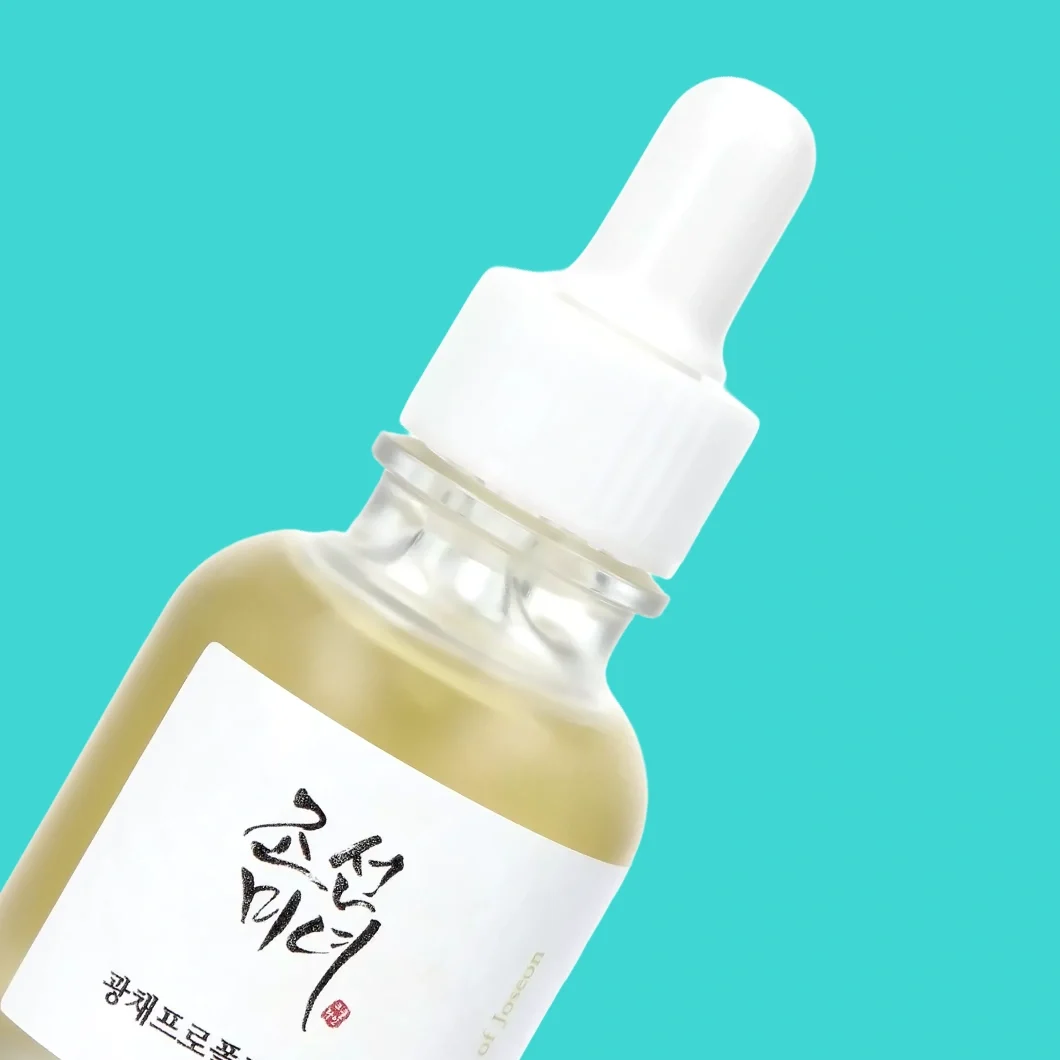 Beauty of Joseon serum i en glassflaske med hvit pipette mot turkis bakgrunn. På etiketten vises koreanske tegn og teksten «of Joseon».