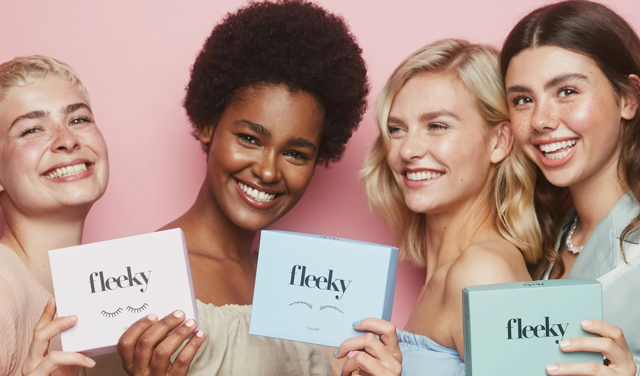 Fire personer holder fleeky-produkter foran en rosa bakgrunn.