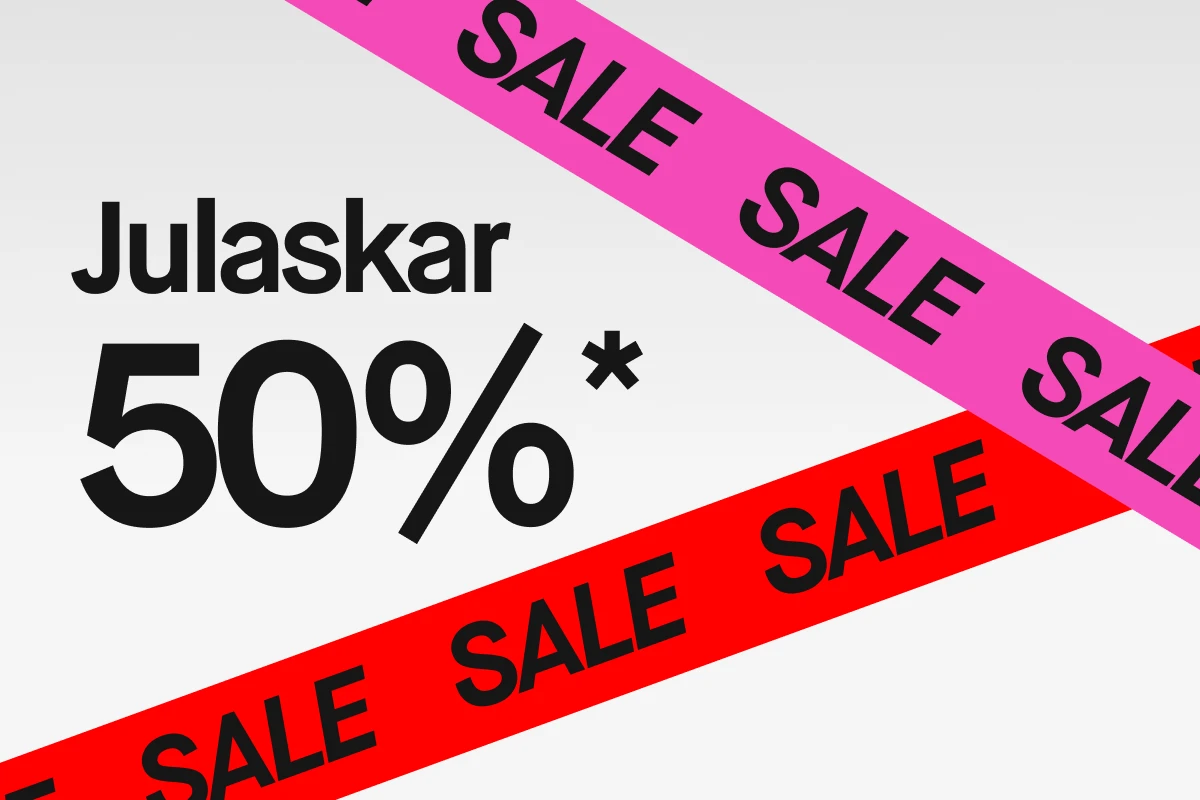 Grafisk bild med vit bakgrund och stor svart text ”Julaskar 50%*”. Två diagonala band korsar bilden: ett rosa och ett rött band med upprepad svart text ”SALE”.