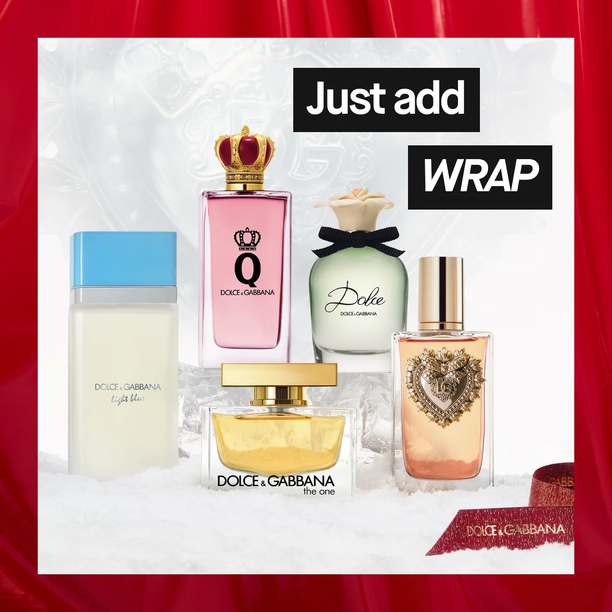 Dolce & Gabbana -tuoksuja eri väreissä ja muodoissa, kuten Light Blue ja The One, lumisella pinnalla vaaleaa taustaa vasten, punaiset verhot reunoilla – ylellinen joulukampanjakuva.