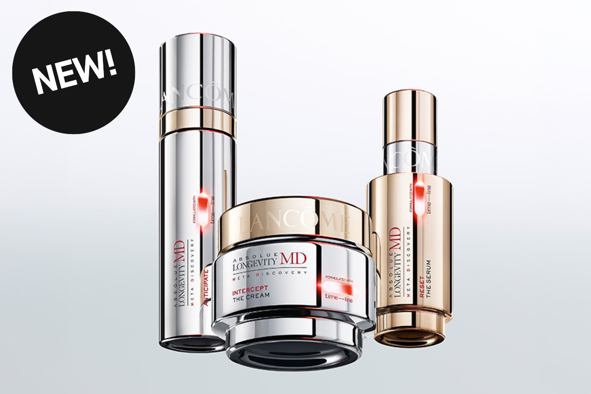 Kolme Lancôme Absolue Longevity MD -ihonhoitotuotetta näkyy vaaleaa taustaa vasten, mukana seerumi ja kasvovoide hopean- ja kullanvärisissä pakkauksissa. Näkyvä teksti sisältää “LANCÔME”, “ABSOLUE LONGEVITY MD”, “META RECOVERY”, “INTERCEPT THE CREAM”, “THE SERUM” sekä musta ympyrä tekstillä “NEW!”.