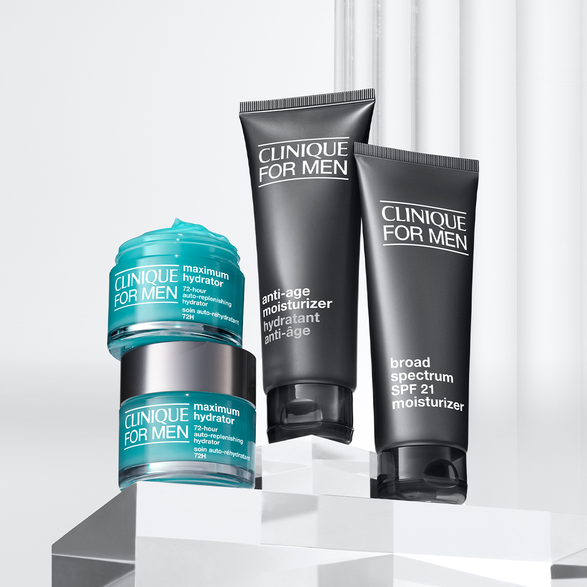 Hudpleieprodukter fra Clinique For Men, inkludert fuktighetskrem og anti-age-produkt, plassert på gjennomsiktige blokker.