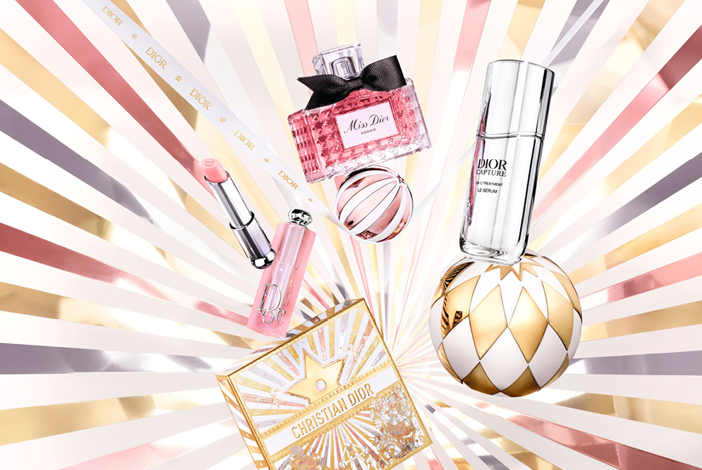 Dior julekampanje med flere Dior produkter foran lysende stjernebakgrunn. 