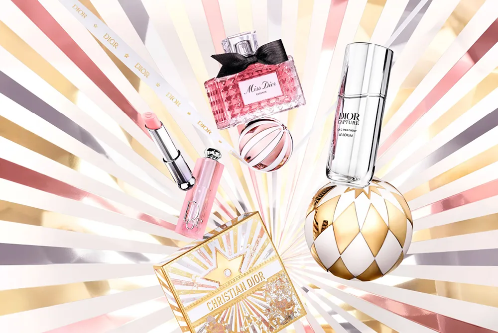 Dior julekampanje med flere Dior produkter foran lysende stjernebakgrunn. 