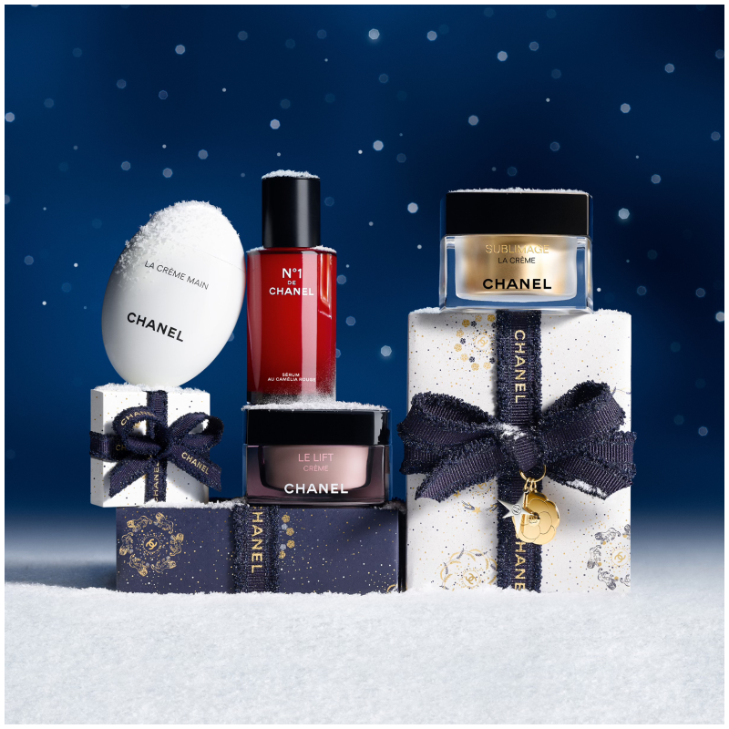 Chanel hudpleieprodukter, inkludert La Crème Main, N°1 de Chanel, Le Lift Crème og Sublimage La Crème, på en snødekt bakgrunn med stjernehimmel.