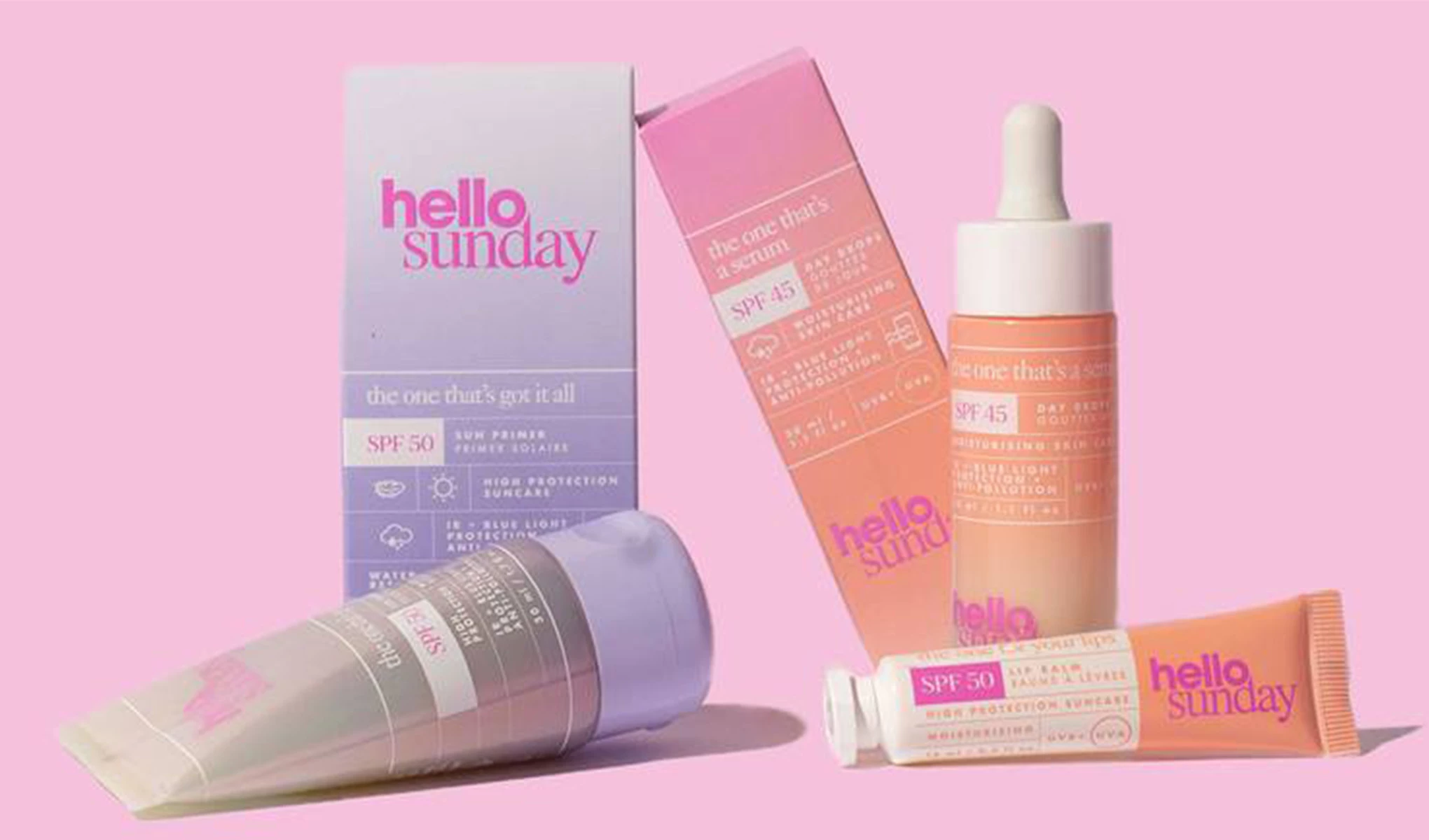 Useita Hello Sunday -merkin aurinkosuojatuotteita vaaleanpunaisella taustalla.