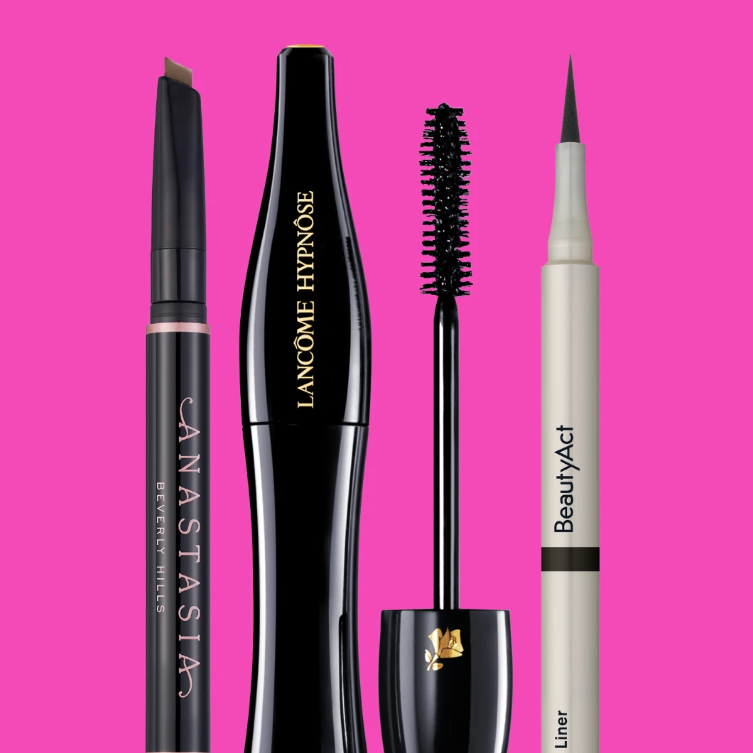 mascara, eyeliner og brynspenn står mot en knæsj rosa bakgrunn
