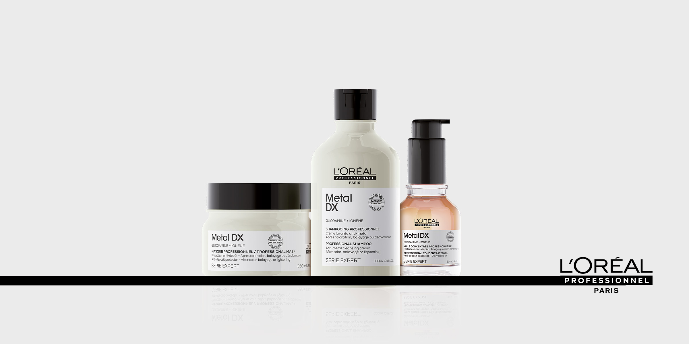 L'Oréal Professionnel Metal DX -sarjan kolme hiustenhoitotuotetta on rivissä vaaleanharmaalla taustalla. Kaikissa tuotteissa on valkoinen etiketti, jossa on musta teksti ja mustat korkit. L'Oréal Professionnel Paris -logo näkyy oikeassa alakulmassa.