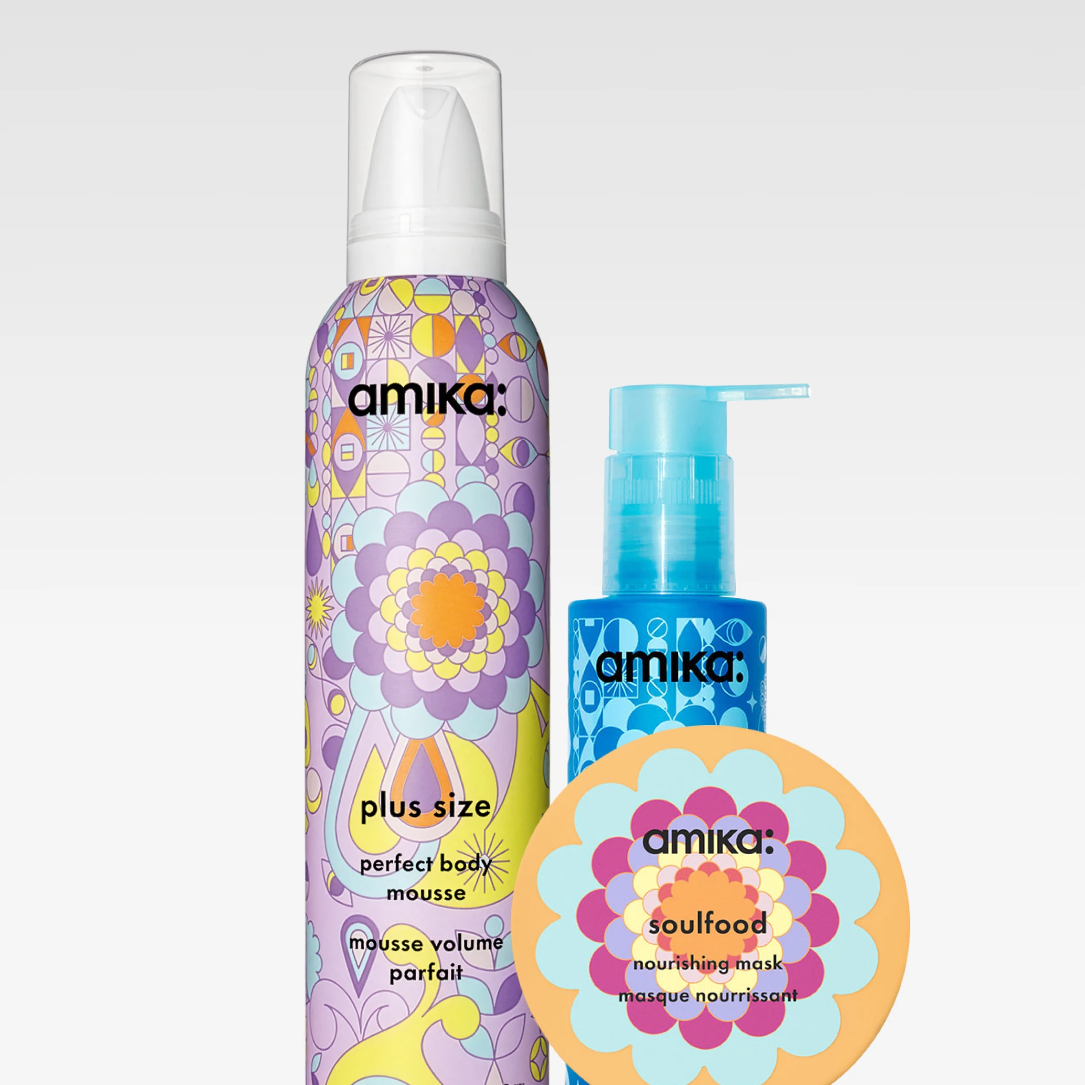 Tre hårvårdsprodukter från amika: “plus size perfect body mousse”, en blå pumpflaska med texten “amika” samt burken “amika soulfood nourishing mask”. Förpackningarna har färgglada mönster och tydlig varumärkestext “amika”.