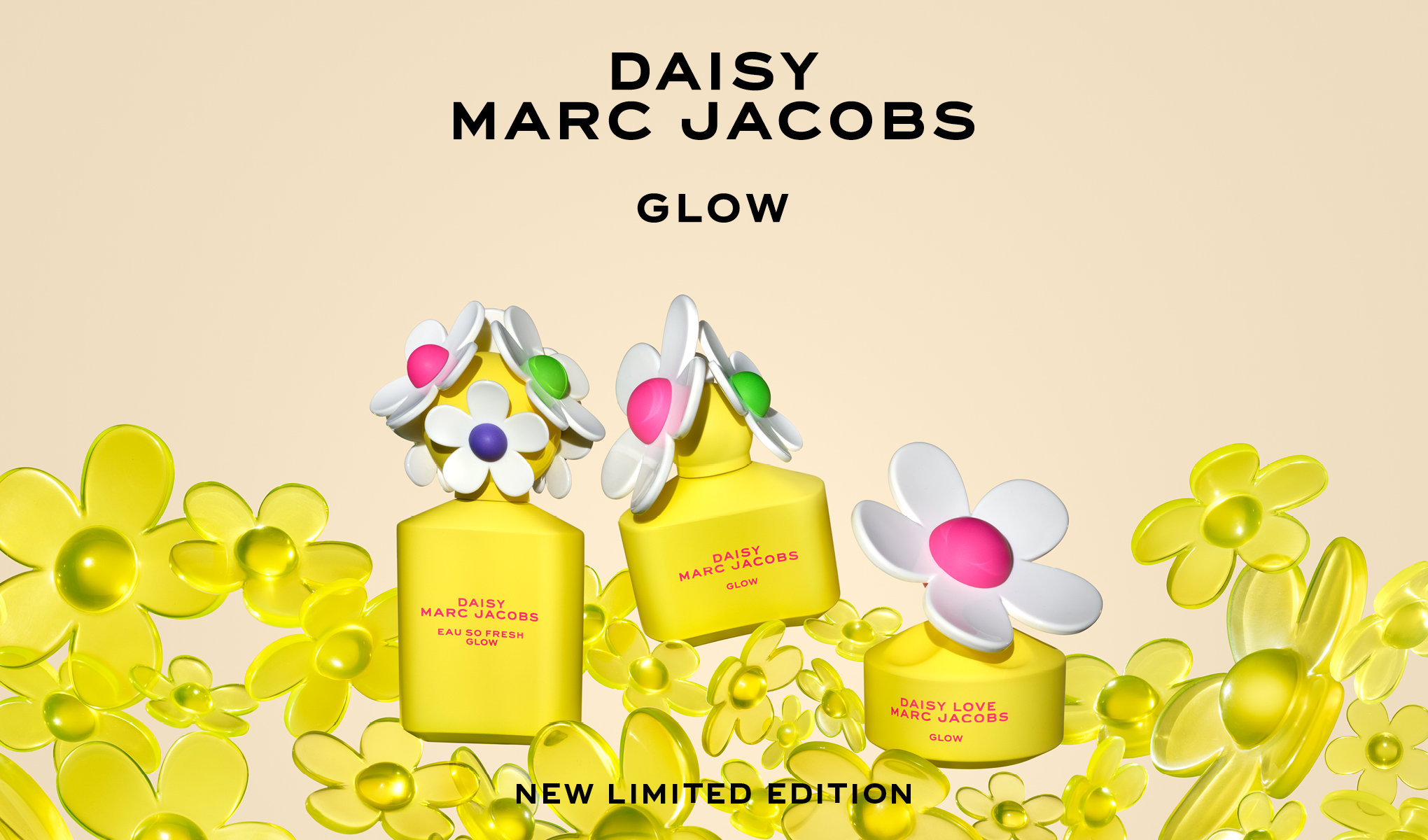 Kolme keltaista Daisy Marc Jacobs -hajuvesipulloa, joissa on kukkien muotoiset korkit, keltaisten kukkien ympäröimänä. Pullojen ylä- ja alapuolella on teksti ”Daisy Marc Jacobs Glow” ja ”New Limited Edition”.